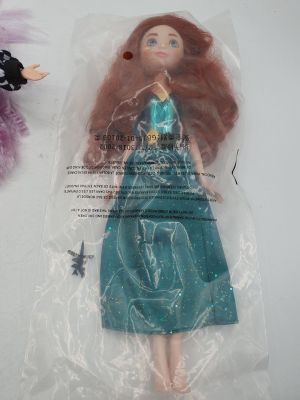 une poupée dans un sac en plastique à côté d'une peluche