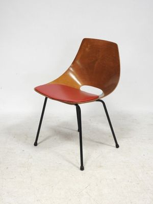 an image of a chair with a red seat and black legs