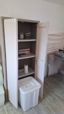 a white trash can sitting in the corner of a room