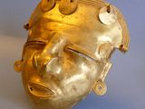a gold mask on a blue surface with a blue background