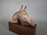 sculpture of a horse ' s head on a wooden block