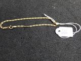 a close up of a gold chain with a tag on it