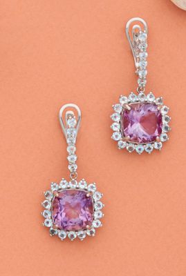 une paire de boucles d'oreilles en saphir rose et diamants sur fond orange