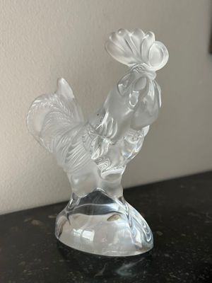 a clear glass figurine of a rooster on a table
