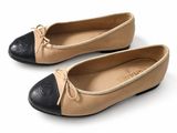 pair of black and tan leather ballet shoes on a white surface