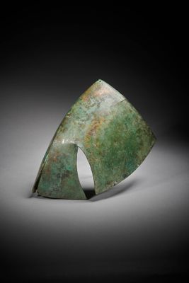 a close up of a green metal object on a black background