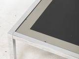a glass top coffee table with a metal frame on it