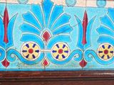 a picture of a blue and red tile on a wooden frame