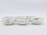 six white coffee cups with floral designs on them sitting on a table