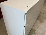 une commode blanche au milieu d'une pièce