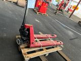 un cariste assis sur une palette dans un entrepôt