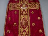 un gros plan sur une robe rouge et dorée ornée d'une croix