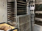 several trays of food sit in a kitchen next to an oven