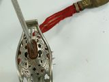 a silver object with a red string around it