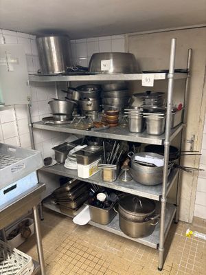 de nombreuses casseroles et poêles sur les étagères de la cuisine