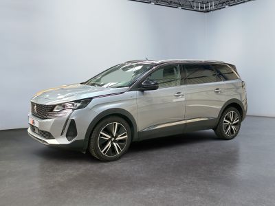 un SUV argenté garé dans une pièce blanche au sol noir