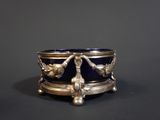 a silver and blue bowl with birds on it on a table