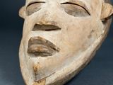 a close up of a wooden mask on a table