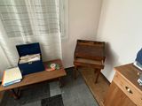 a small room with a desk, chair, and piano in it