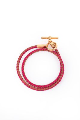 un bracelet rose avec un fermoir doré sur fond blanc