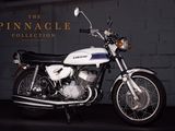 une moto blanche garée devant un mur de briques