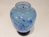 a blue glass vase sitting on a white table