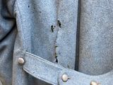 a man wearing a blue coat with buttons on it