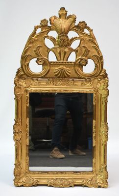 un miroir avec un cadre doré dans lequel se reflète un homme