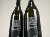 two bottles of wine sitting next to each other on a table
