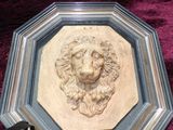 a sculpture of a lion ' s head on a plaque