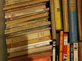 many books that are stacked together on a shelf