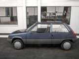 a small blue car parked in front of a building