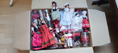 a cardboard box with a bunch of dolls in it