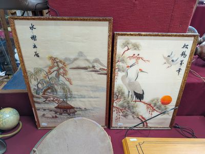 two asian paintings on a table with a bowl and a plate
