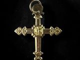 a close up of a gold cross on a black background