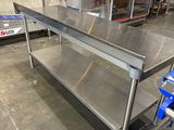 une grande table en acier inoxydable au milieu d'un entrepôt