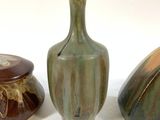 three vases sitting next to each other on a white surface