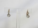 a pair of diamond earrings on a clear display stand