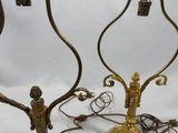 pair of antique brass candlesticks with figurines on top of them