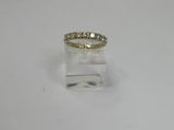 a yellow gold ring with diamonds on top of a clear acrylic block