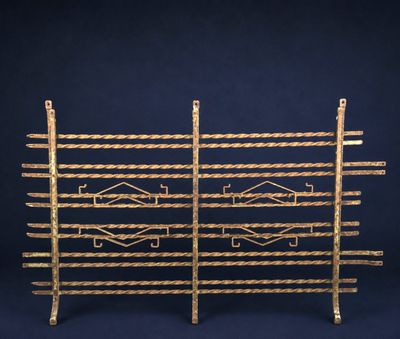 une paire de supports en métal plaqué or ornés de motifs géométriques