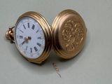 une montre de poche en or avec des chiffres romains