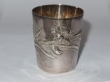a silver cup with a monkey on it on a table