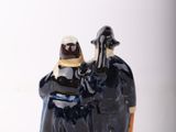 a figurine of a man and a woman sitting on a rock