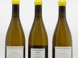 three bottles of wine sitting next to each other on a white surface