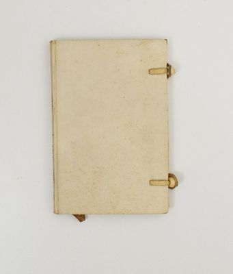 un vieux livre sur lequel repose une page blanche, posé sur une surface blanche
