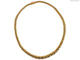 gros plan d'un collier en or sur fond blanc