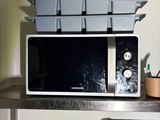 a microwave that is sitting on a shelf in the kitchen
