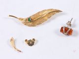 a gold leaf brooch and earrings on a white surface