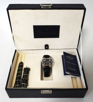 a watch and a pen in a box on a table